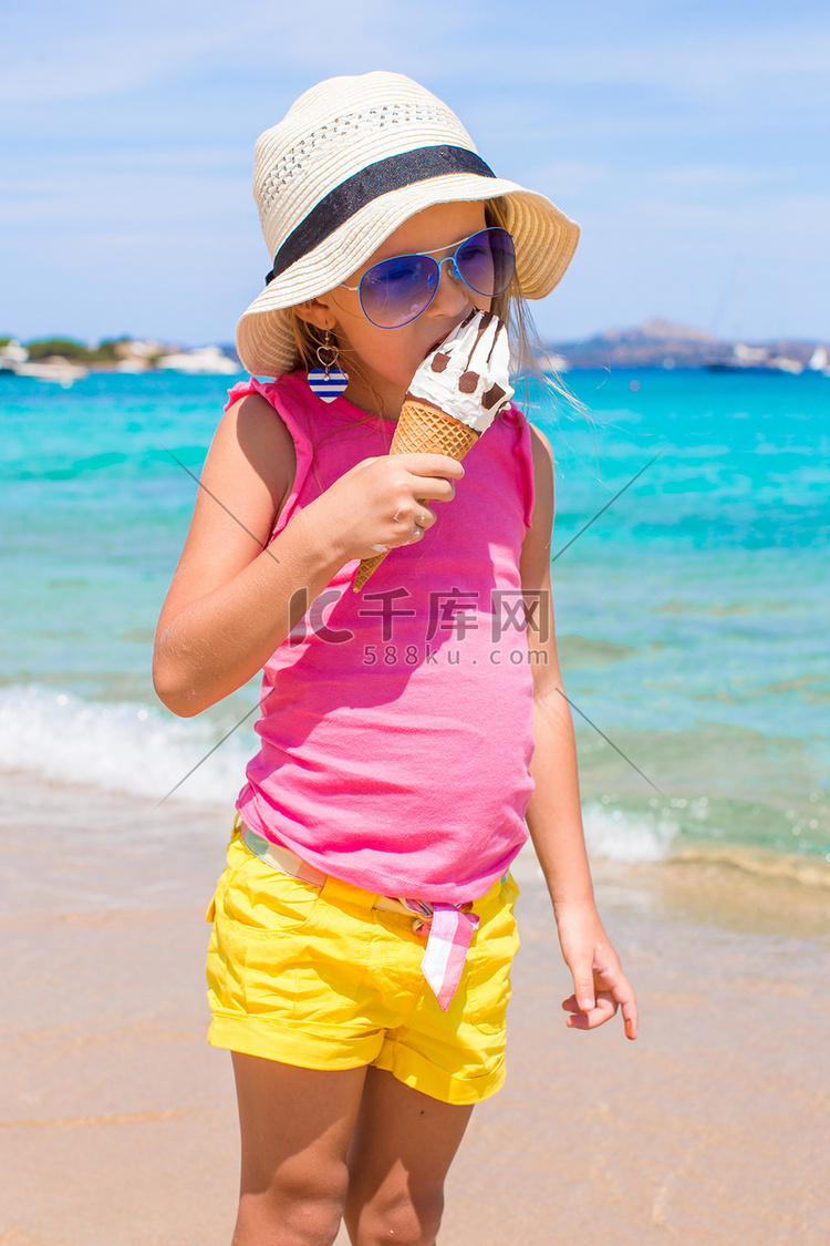可爱的小女孩在海滩度假期间玩得