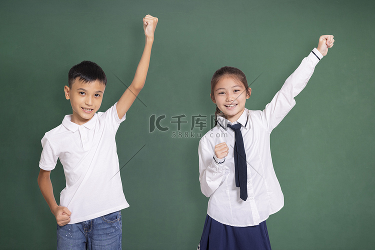 快乐的学生男孩和女孩举手