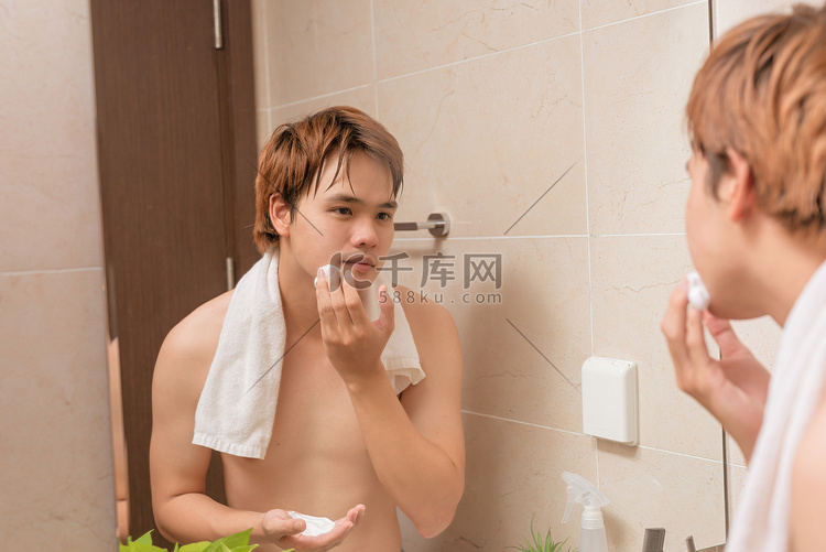 英俊的男人在浴室里剃胡子