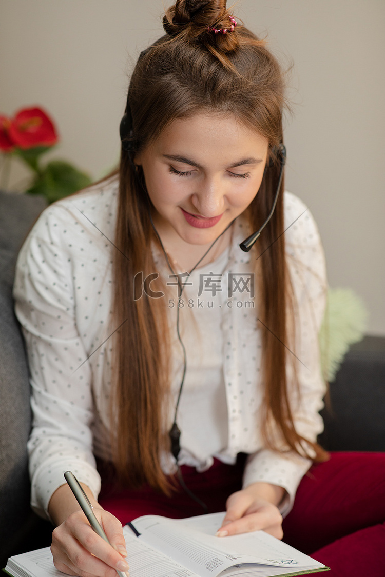 微笑的少女戴着耳机听音频课程做