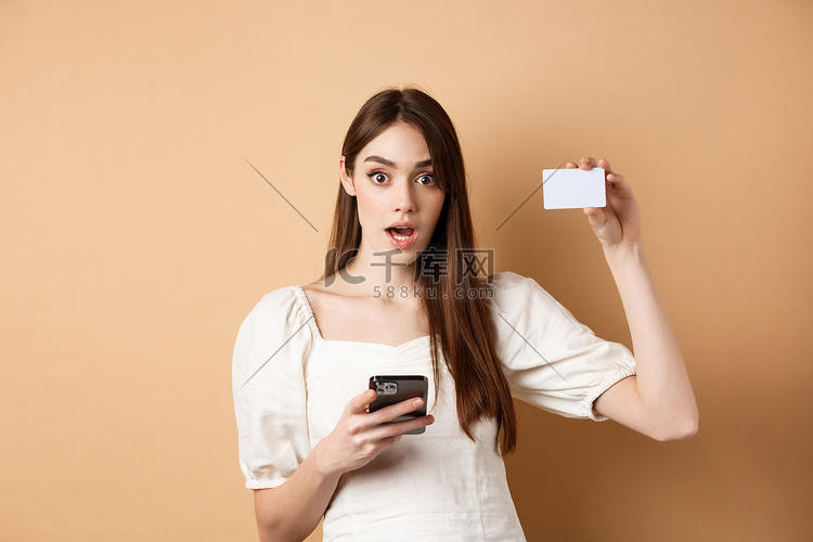 兴奋的女人出示塑料信用卡并使用