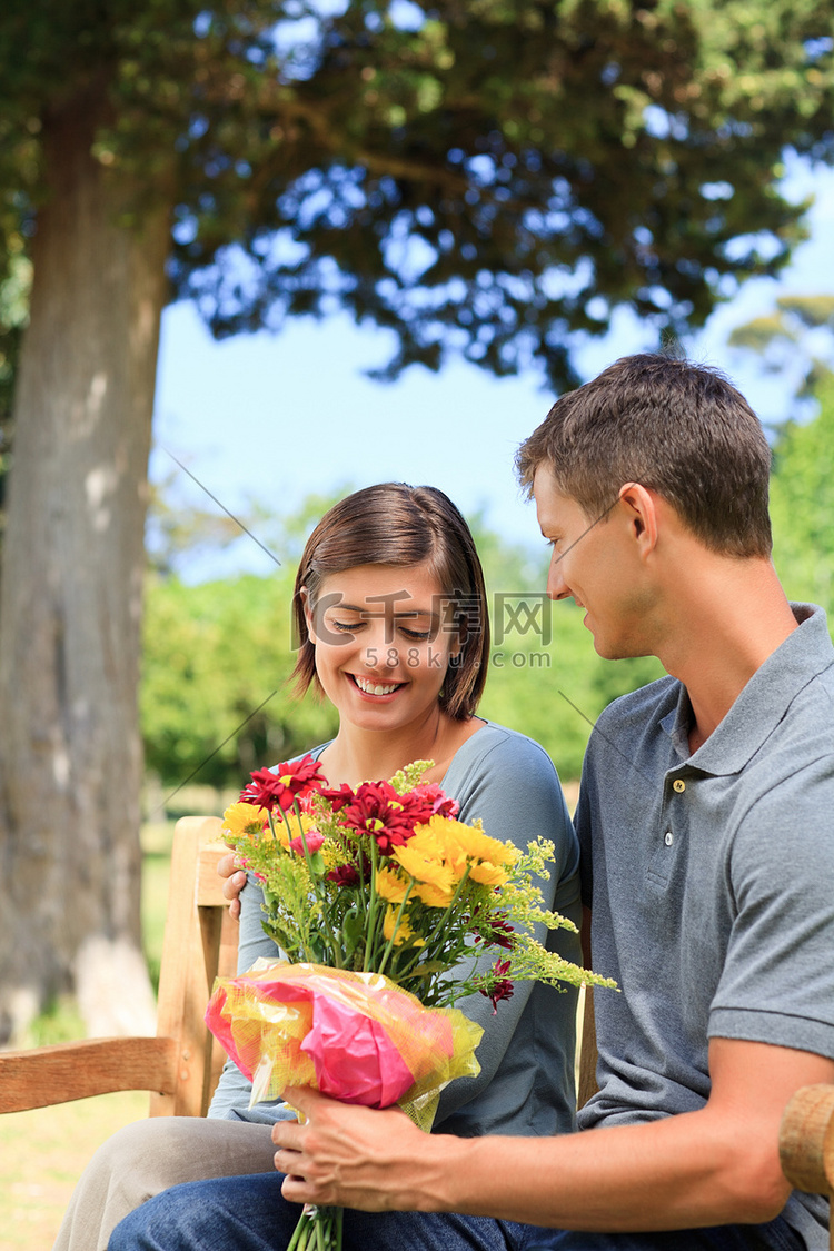 蓝天背景下，年轻人向女友献花