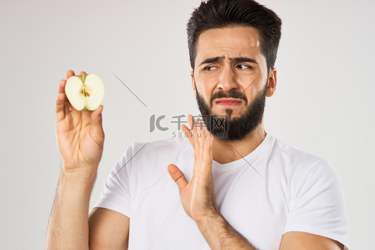 情绪化的大胡子男人手里拿着苹果