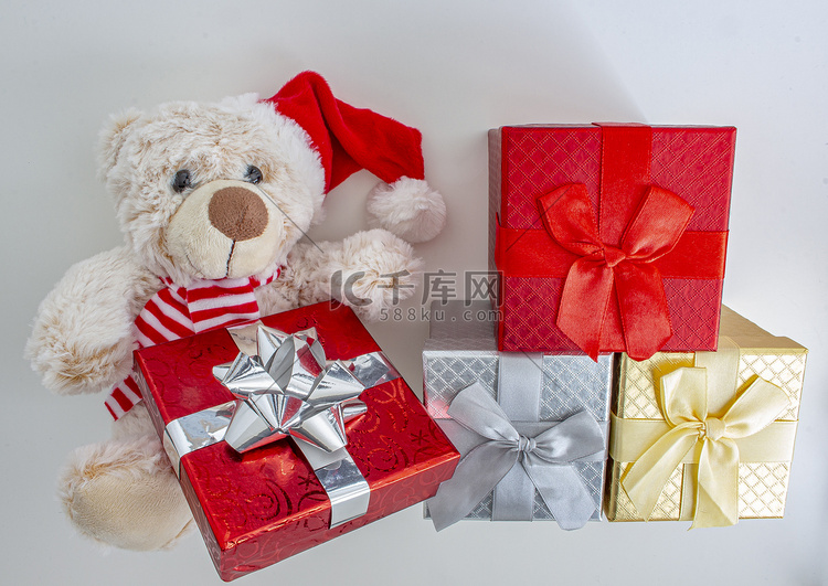浅棕色泰迪熊，戴着圣诞帽和礼物