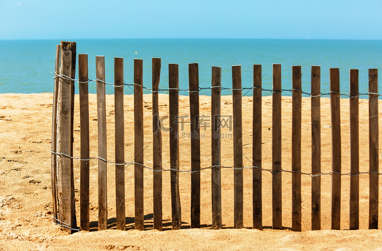 在海洋附近的沙滩上的栅栏。