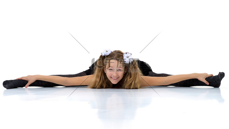 女孩坐在地板上，双腿分开