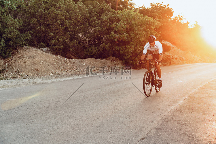 夕阳西下，男子骑自行车在户外骑