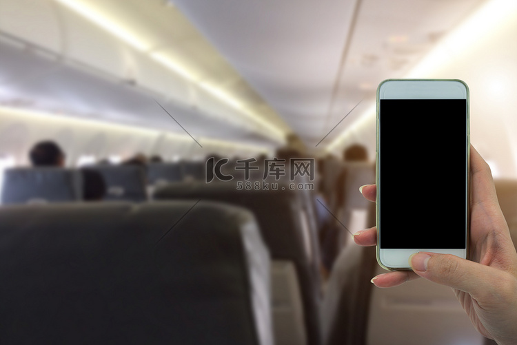 女人在飞机模糊背景中使用手机