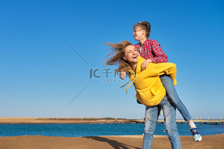 快乐的母女在海边，在沙滩上放松