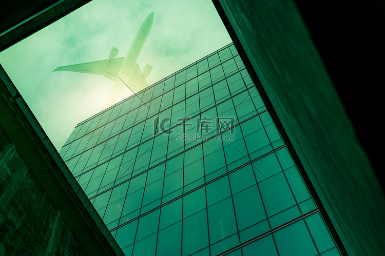 底视图现代玻璃办公楼，一架飞机