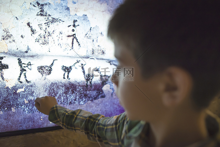 孩子看着一幅古老的壁画