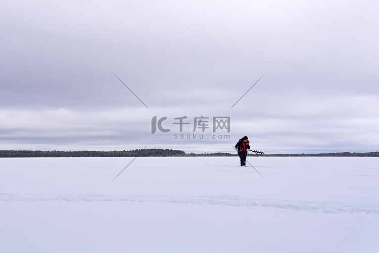 冬天湖上的渔民用电钻钻冰