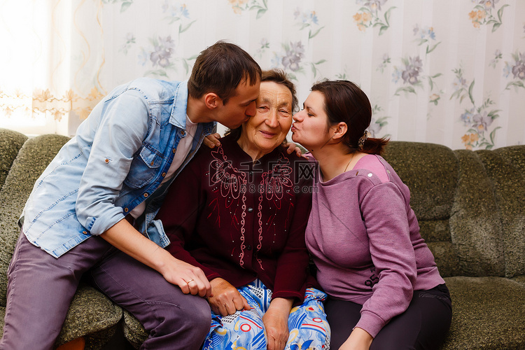 成年微笑的孙子拥抱年迈的祖母，