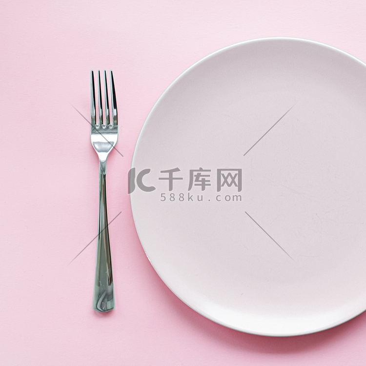 空盘子和餐具作为模型设置在粉红