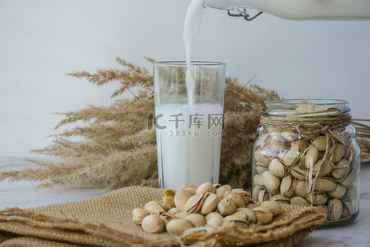 将植物奶倒入一杯不含开心果乳糖