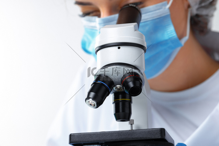 女科学家用显微镜工作的特写照片