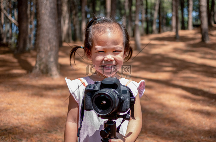 快乐的亚洲小孩站在泰国的松树林