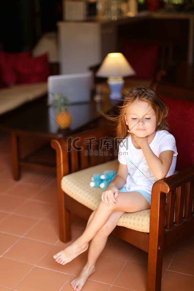 小欧洲女模特坐在木椅上，拿着玩