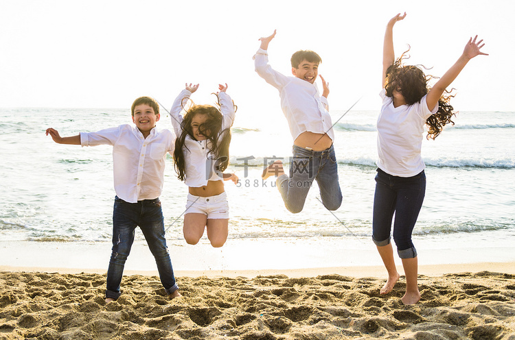快乐的孩子们在海滩上一起跳跃