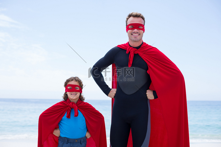 超级英雄服装的父亲和儿子在海边