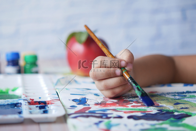 小女孩用艺术画笔在纸上画画