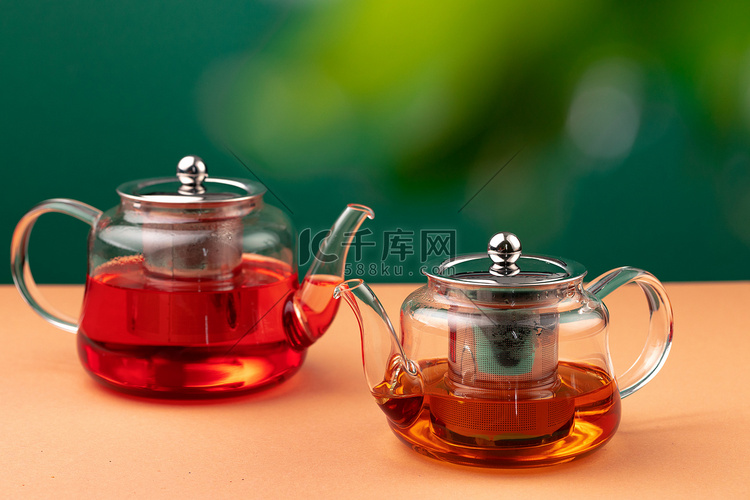 树叶模糊背景下的红茶玻璃茶壶