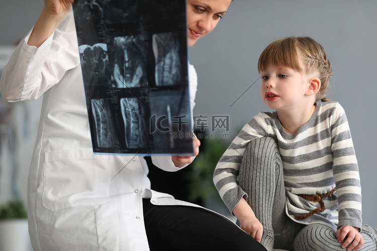 女医生给小女孩看了脊柱X光检查