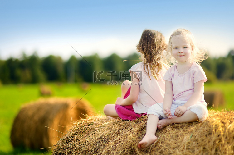 两个小姐妹坐在干草堆上