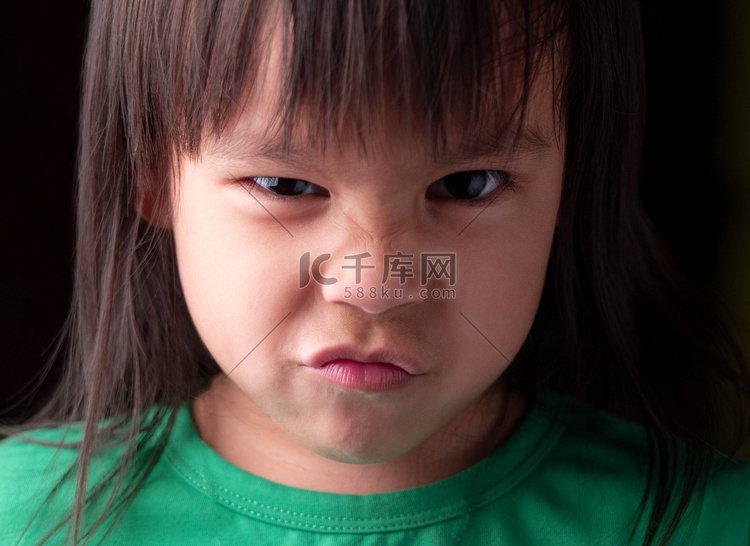 亚洲小女孩的肖像脸，在深色背景