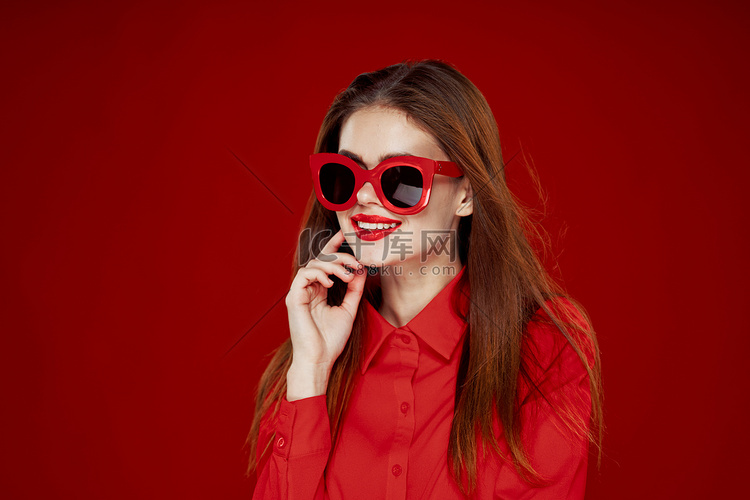 有魅力的女人在红色衬衫太阳镜时