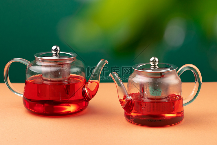 树叶模糊背景下的红茶玻璃茶壶