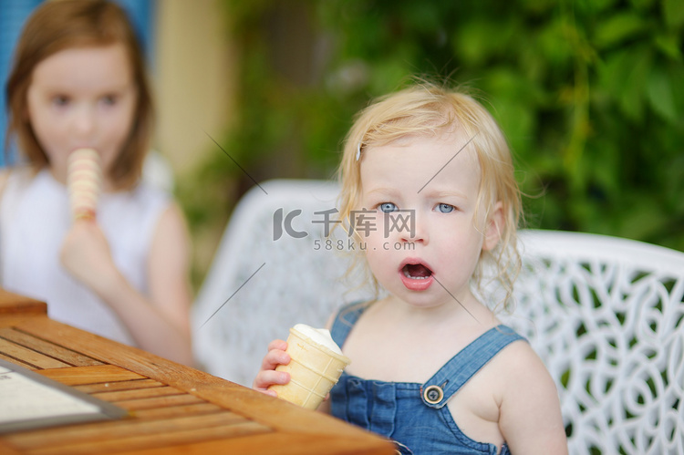 两个小姐妹在户外吃冰淇淋