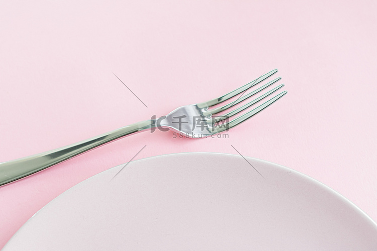 空盘子和餐具作为模型设置在粉红