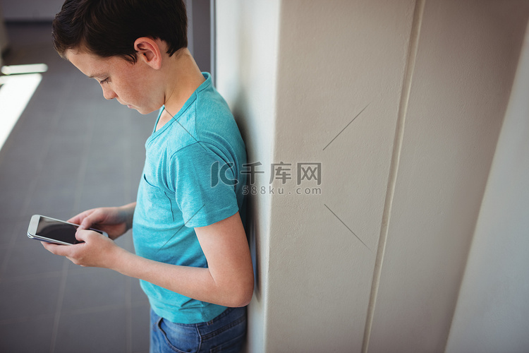 小学生在学校走廊里使用手机