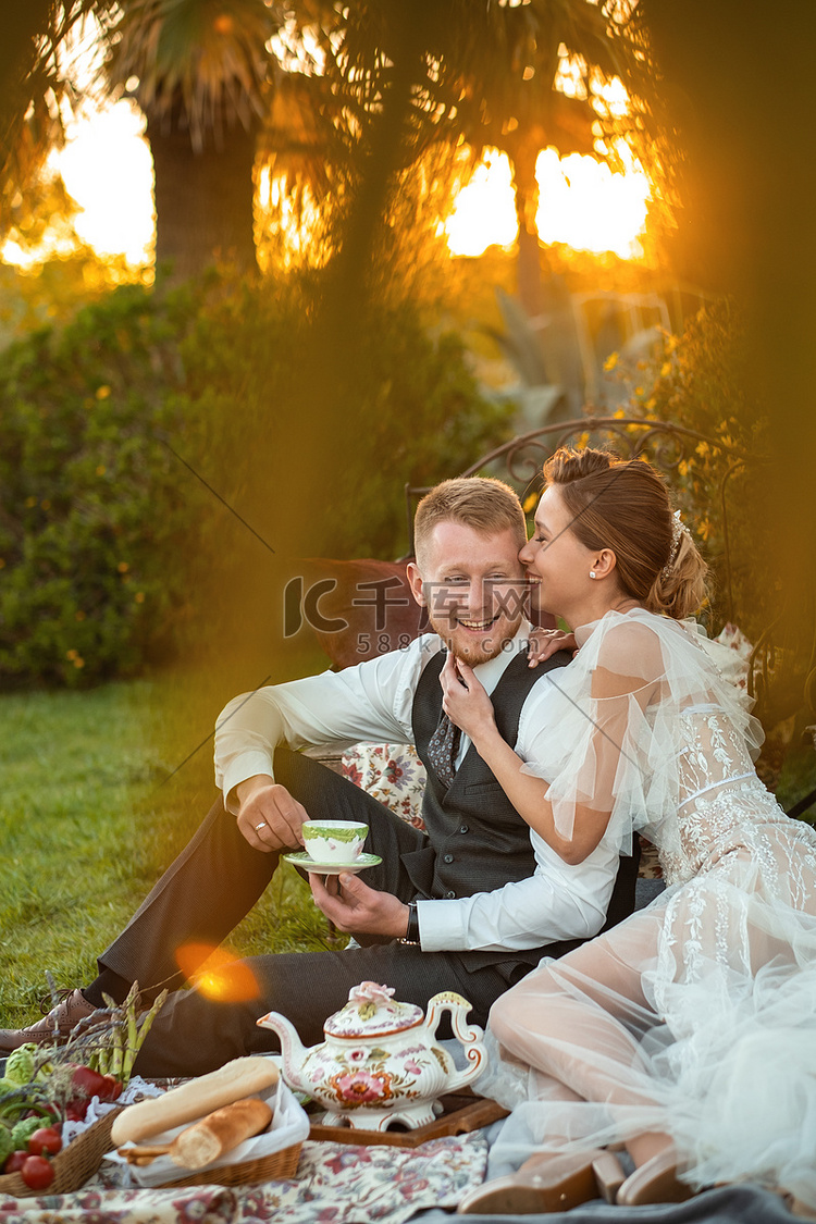 日落时分，新婚夫妇在草坪上共进