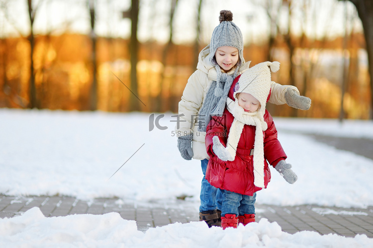 两个小姐妹在下雪的冬日玩得开心