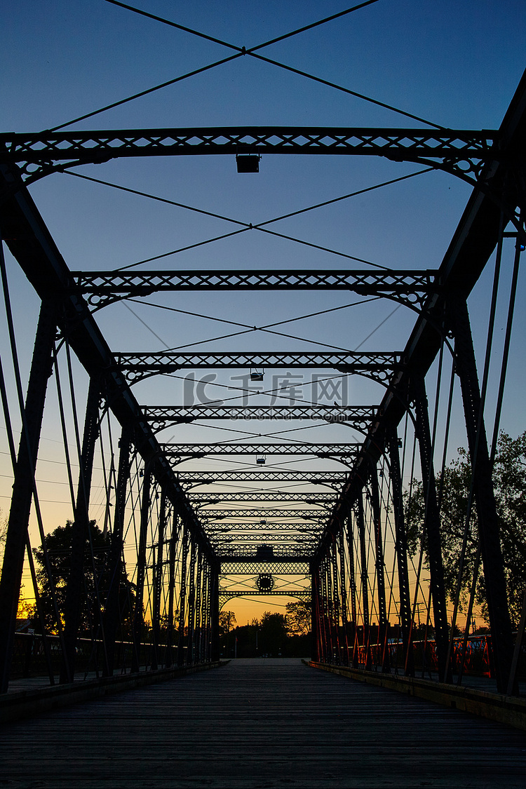 金属桥延伸至远方，在橙色夕阳的
