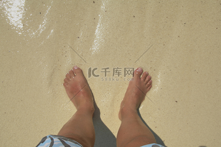 赤脚在加勒比海滩的水中