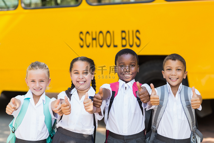 微笑的孩子们在校车前竖起大拇指