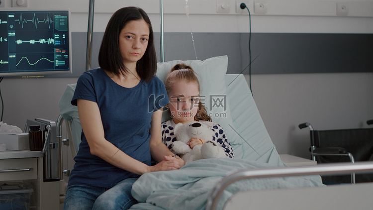 忧心忡忡的母亲坐在住院的小孩旁