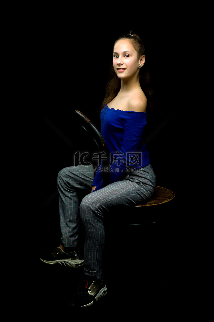一个小女孩坐在一把旧维也纳椅子