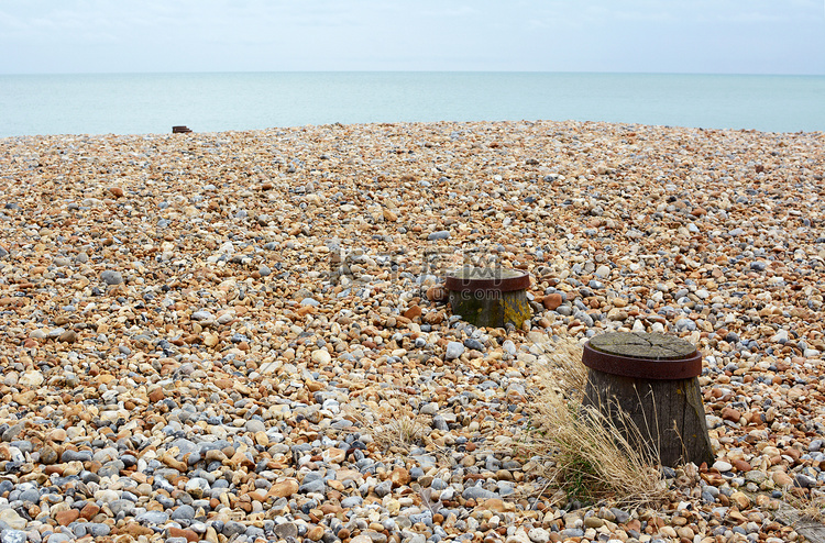 英国海岸的卵石海滩，配有木制防