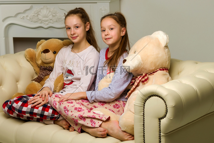 穿着睡衣的漂亮女孩和大泰迪熊坐