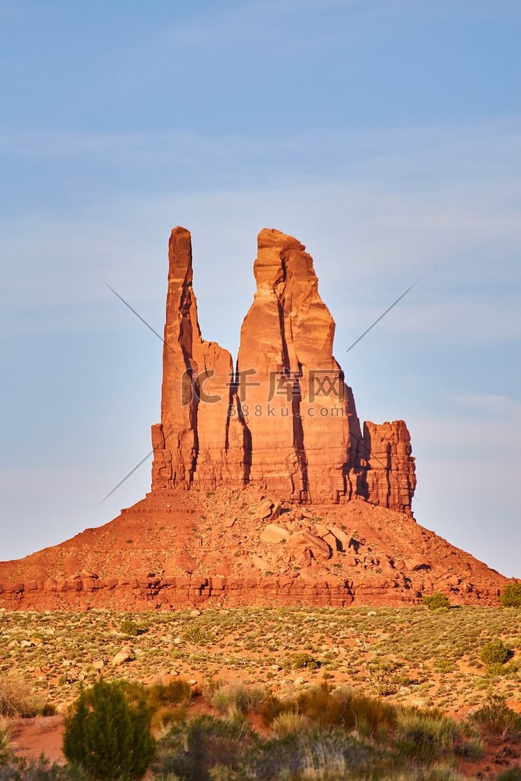 垂直的大红色岩柱在蓝天沙漠中