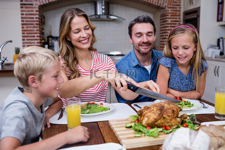 和家人一起吃饭时切烤火鸡的女人