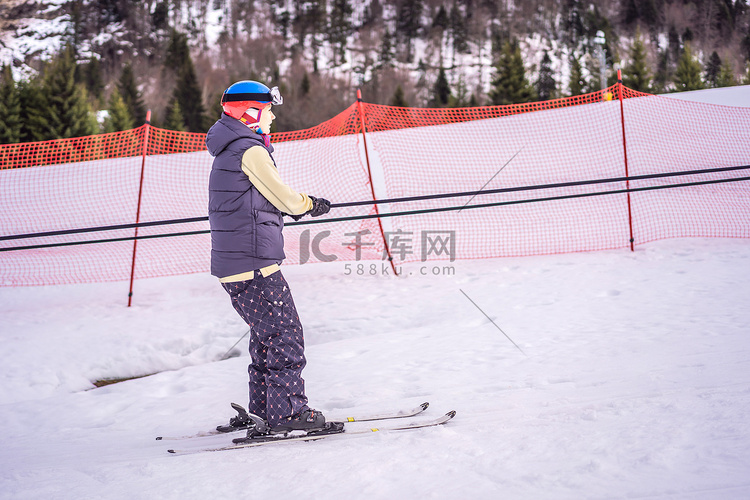 女滑雪者在初学者滑雪缆车上爬山