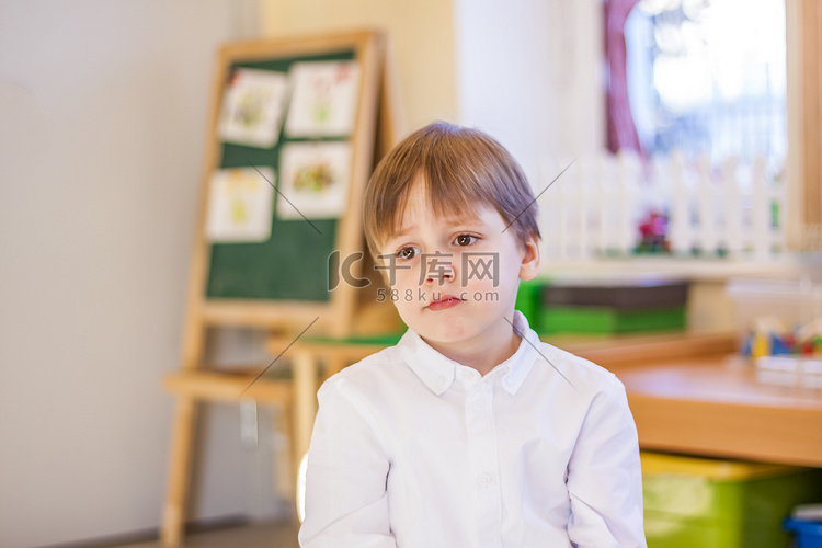 一个穿着优雅白衬衫的小男孩坐在