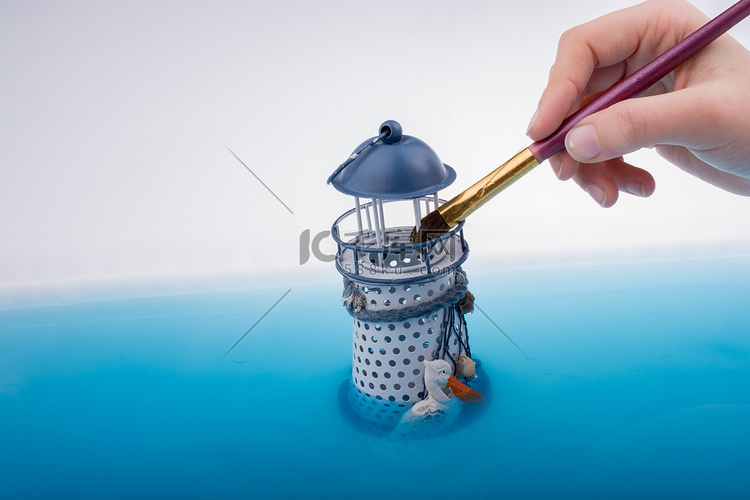 画笔和水中小模型灯塔