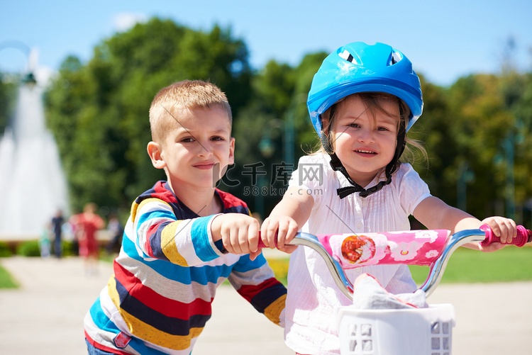 男孩和女孩在公园学习骑自行车