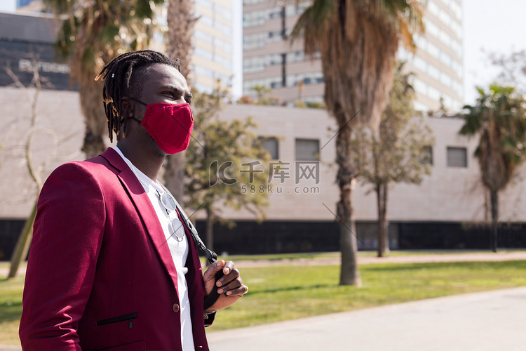 非洲男子戴着面具走路以搭配他的